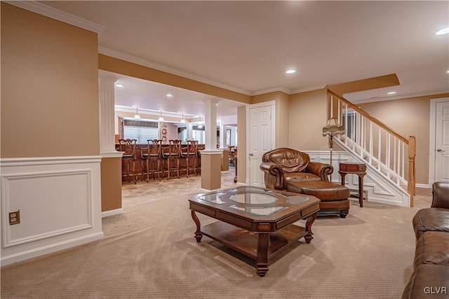 living room featuring a decorative wall, light carpet, stairway, decorative columns, and crown molding