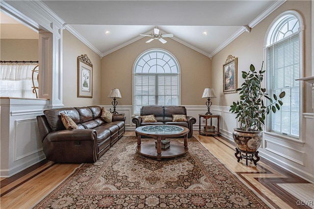 living area with a wainscoted wall, a wealth of natural light, and wood finished floors