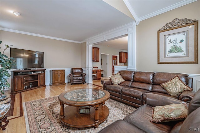 living room featuring a wainscoted wall, light wood-type flooring, decorative columns, and crown molding