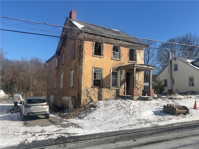 view of front of property with a chimney and stucco siding