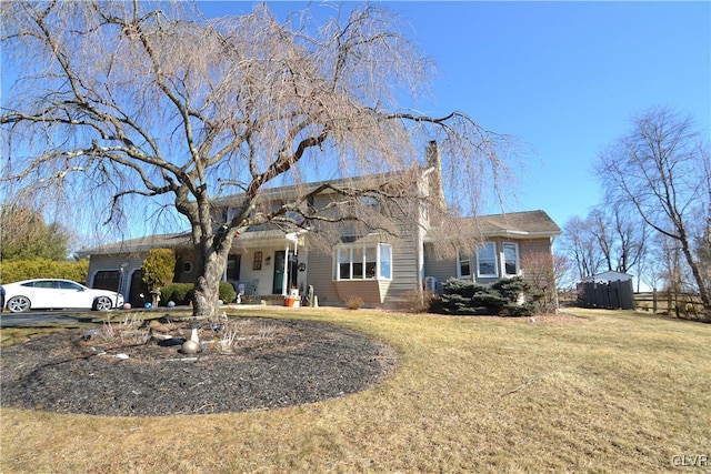 view of front of home with a garage, driveway, a chimney, and a front lawn