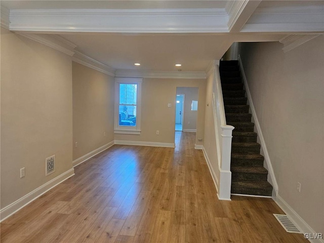 foyer with crown molding, visible vents, stairway, light wood-style flooring, and baseboards