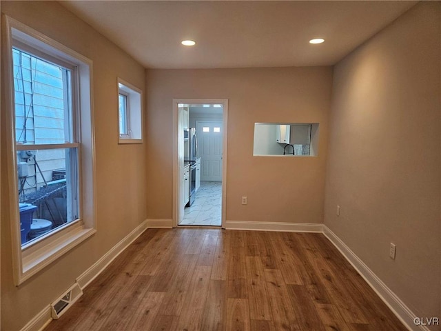 interior space featuring light wood-style floors, recessed lighting, visible vents, and baseboards