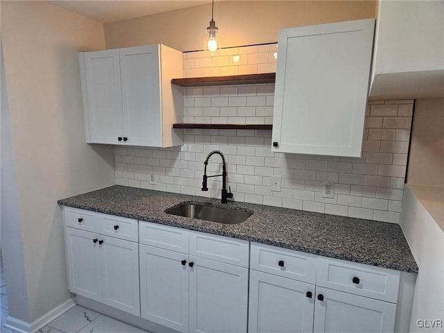 kitchen featuring white cabinetry, a sink, and open shelves