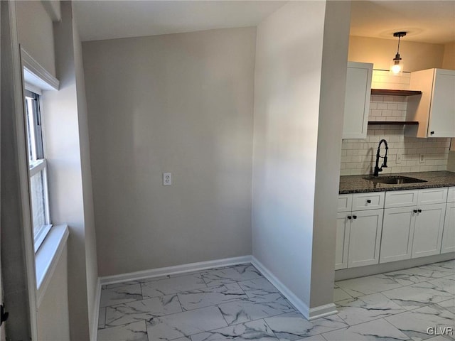 kitchen featuring a sink, marble finish floor, open shelves, and white cabinets