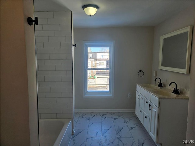 full bath featuring marble finish floor, double vanity, a sink, and baseboards