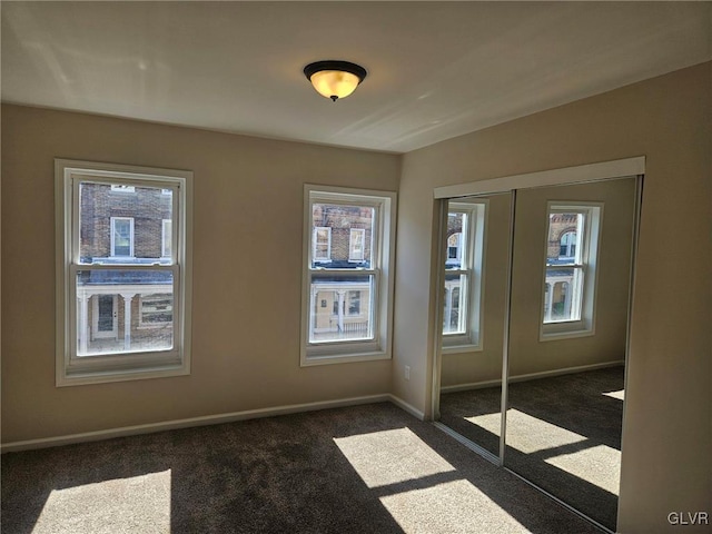 empty room featuring french doors, dark carpet, and baseboards