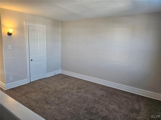 unfurnished room with carpet flooring and baseboards