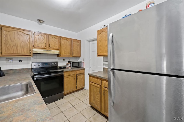 kitchen with light tile patterned floors, appliances with stainless steel finishes, backsplash, under cabinet range hood, and a sink