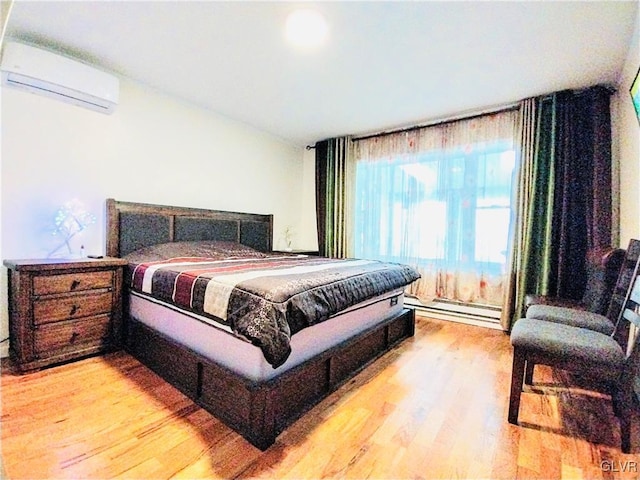 bedroom featuring a wall unit AC, light wood-style flooring, and baseboard heating