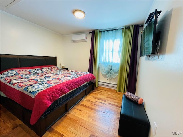 bedroom featuring a baseboard heating unit, wood finished floors, and a wall mounted air conditioner