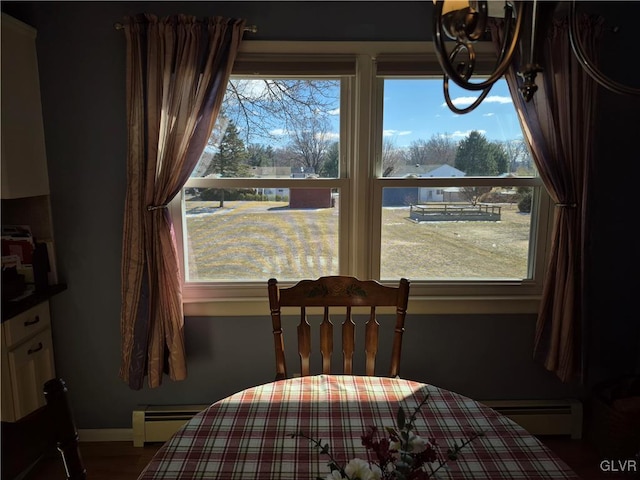 dining room featuring baseboards, plenty of natural light, and baseboard heating