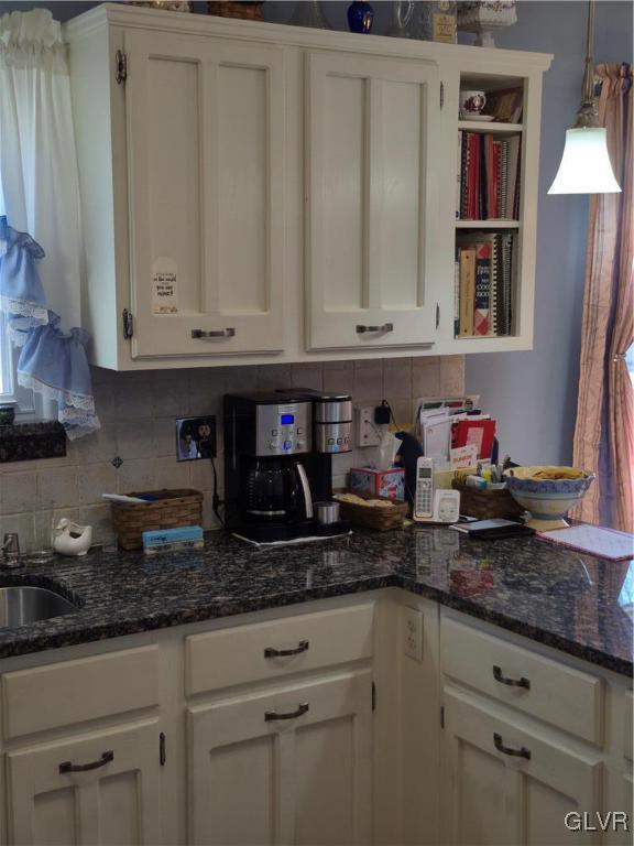 kitchen with open shelves, pendant lighting, white cabinets, and backsplash