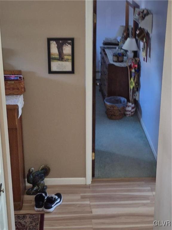 hallway featuring baseboards and wood finished floors