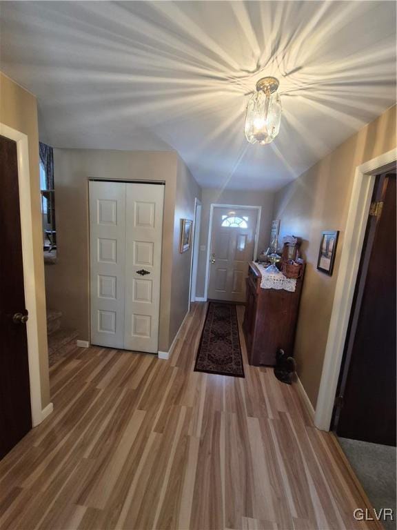 entryway featuring stairway, wood finished floors, and baseboards