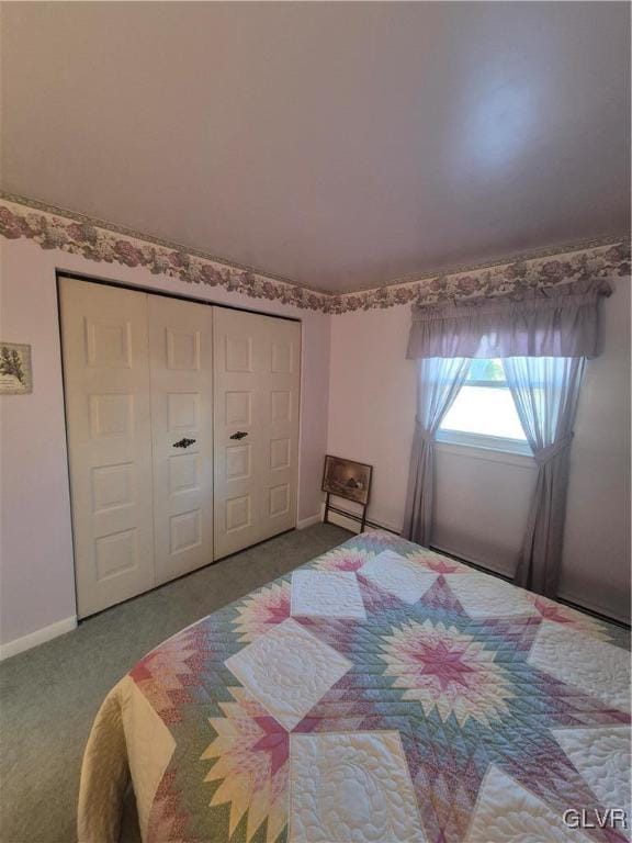 carpeted bedroom with baseboards and a closet