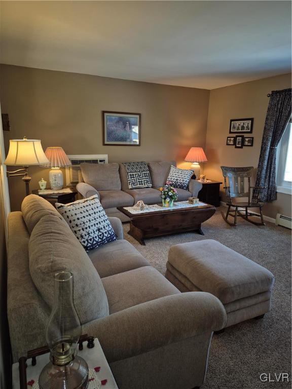 living area with carpet floors, a baseboard radiator, and baseboards