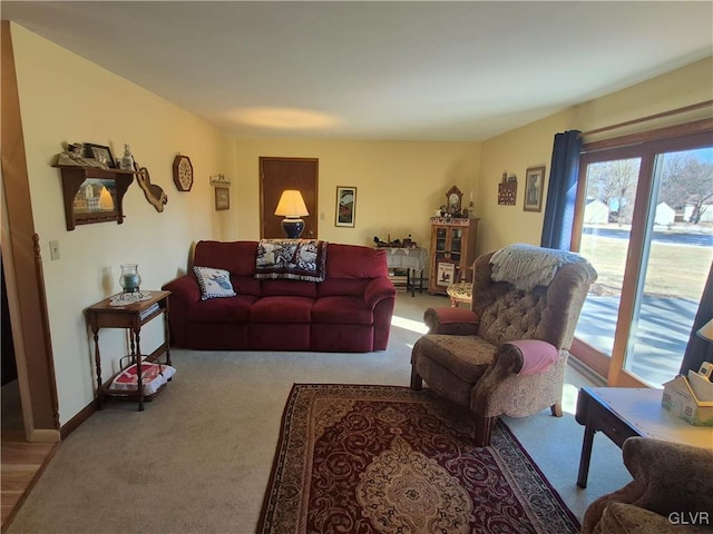 living area featuring baseboards and light colored carpet