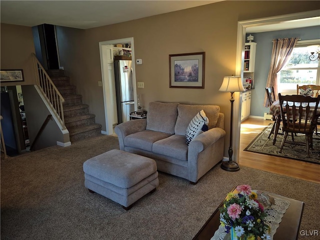 living area with stairs, baseboards, and wood finished floors