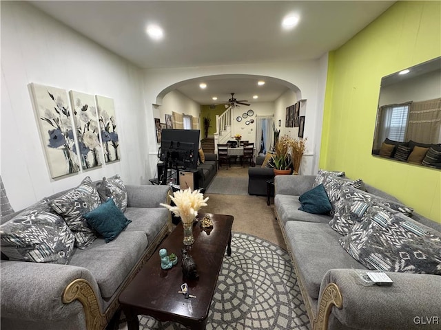 carpeted living area with arched walkways, a ceiling fan, and recessed lighting