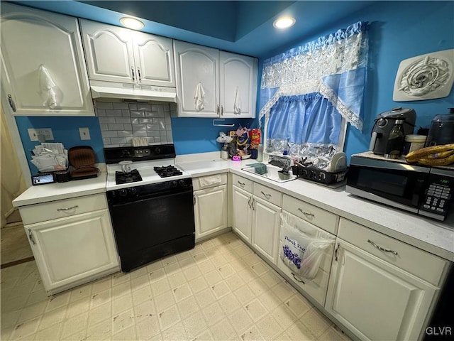 kitchen featuring range with gas cooktop, light countertops, a sink, and under cabinet range hood