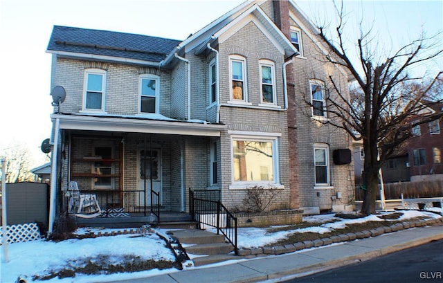 view of front of property with covered porch and brick siding