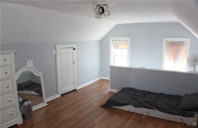 bedroom featuring dark wood-style flooring, vaulted ceiling, and baseboards