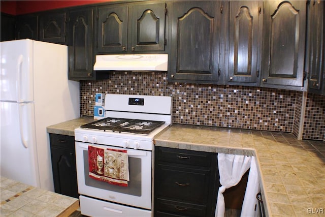 kitchen with white appliances, backsplash, tile counters, and under cabinet range hood