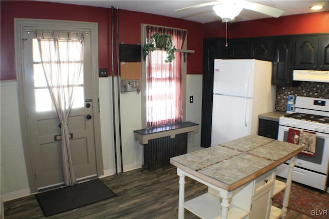 kitchen featuring white appliances, tile counters, dark wood finished floors, a ceiling fan, and under cabinet range hood