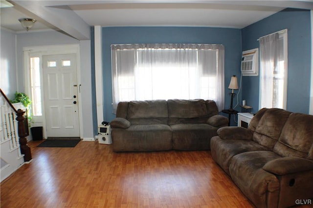 living room featuring stairway, wood finished floors, and a wall mounted air conditioner