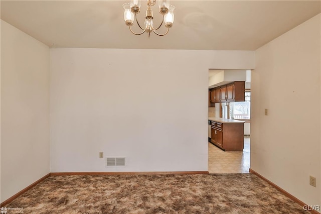 unfurnished dining area with baseboards, visible vents, a notable chandelier, and light colored carpet