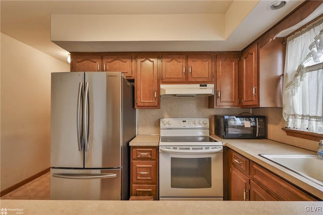 kitchen with white electric stove, freestanding refrigerator, light countertops, under cabinet range hood, and black microwave