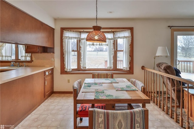 dining space with light floors and baseboards