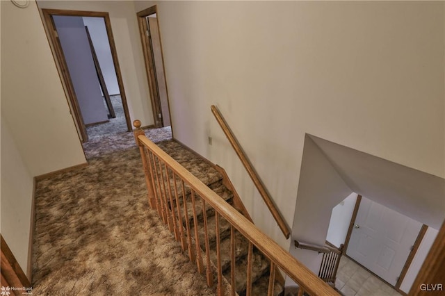 hallway with light carpet and an upstairs landing