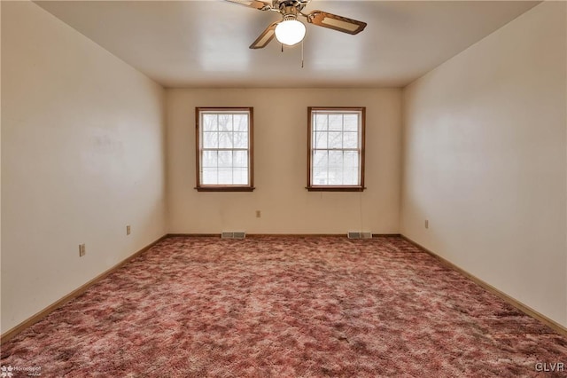 carpeted spare room featuring visible vents, ceiling fan, and baseboards