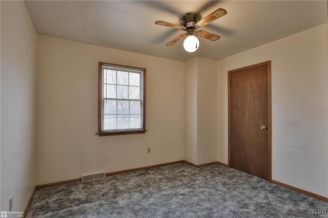 carpeted empty room with ceiling fan, visible vents, and baseboards