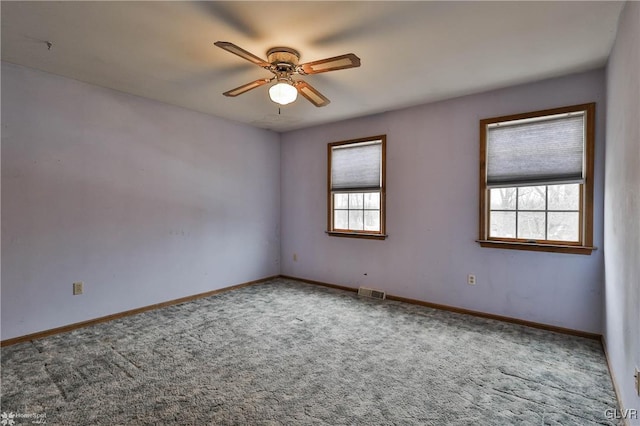 unfurnished room with carpet, visible vents, ceiling fan, and baseboards