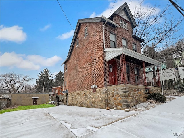 view of side of home with brick siding and a porch