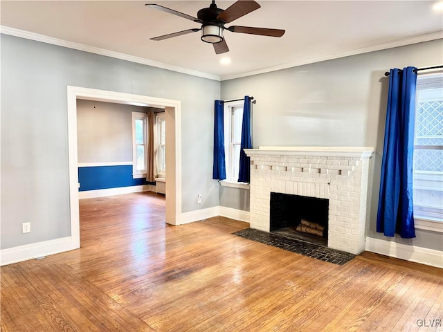 unfurnished living room with crown molding, baseboards, and wood finished floors