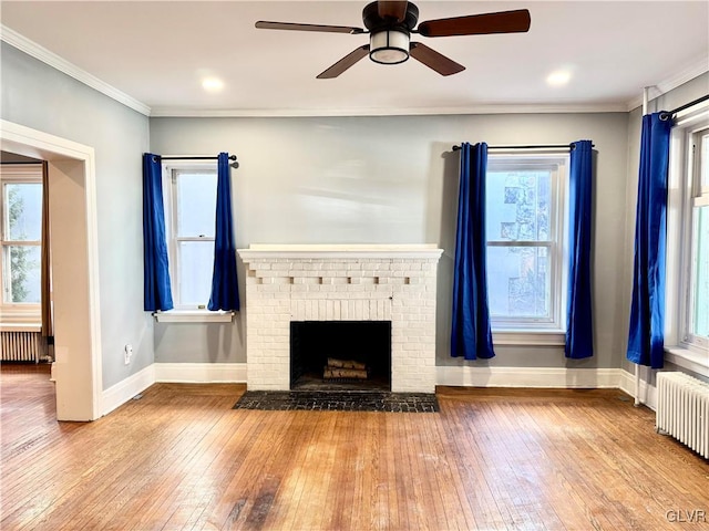 unfurnished living room with crown molding, radiator heating unit, and wood finished floors