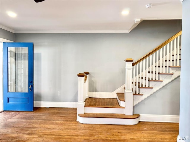 staircase featuring ornamental molding, baseboards, and wood finished floors