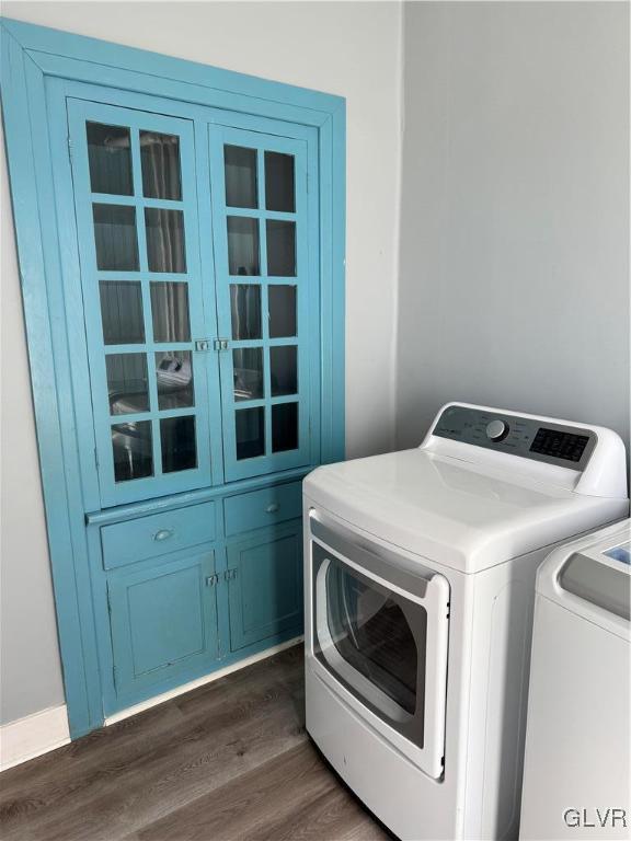 laundry room featuring separate washer and dryer, dark wood finished floors, and cabinet space