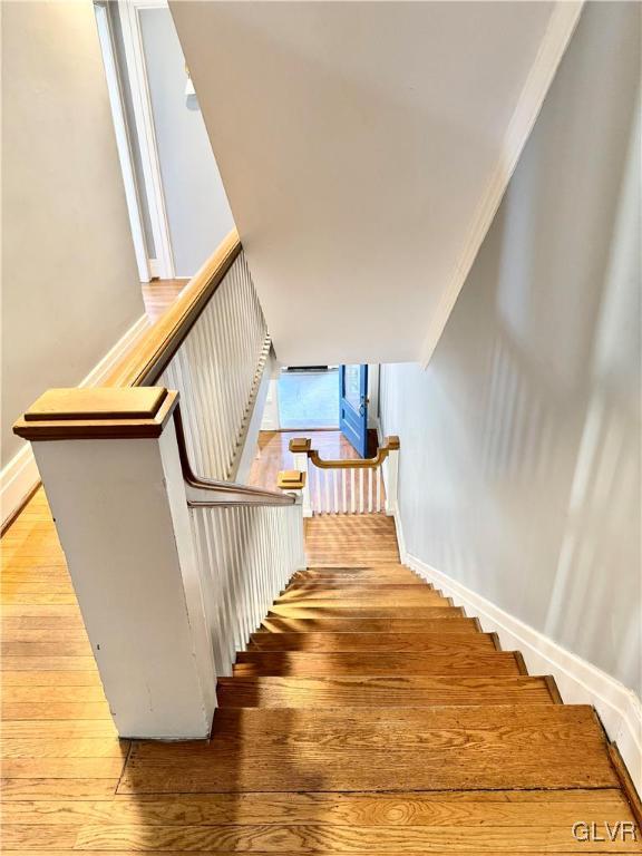 staircase with baseboards and wood finished floors