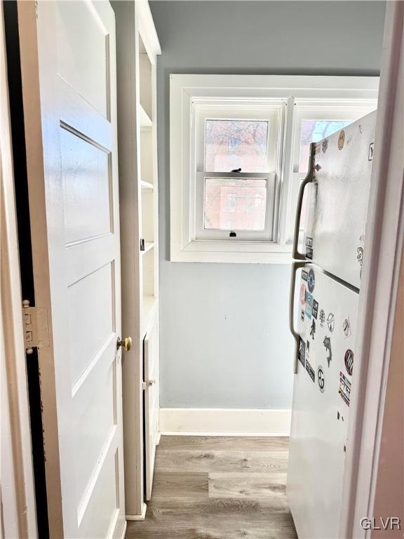 interior space featuring light wood-style flooring and baseboards