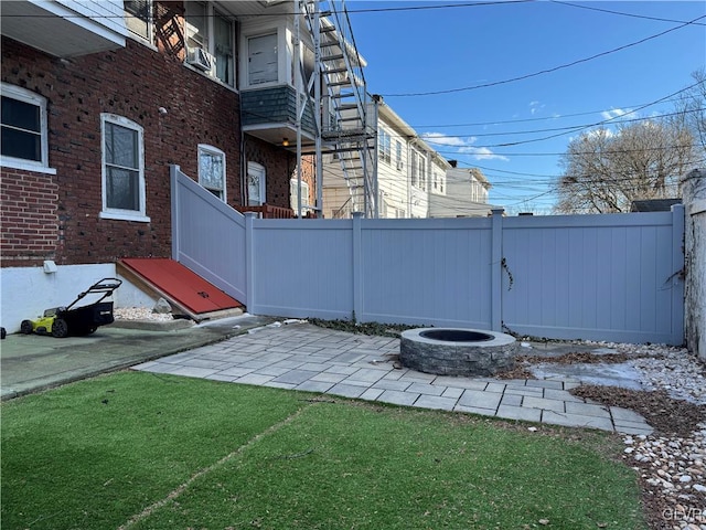 view of yard featuring a patio area, fence, and a fire pit