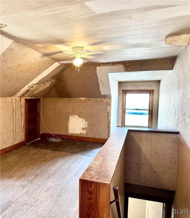 bonus room with a ceiling fan, baseboards, vaulted ceiling, and light wood finished floors