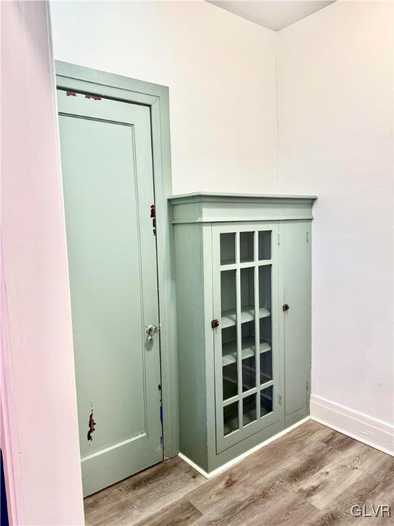 doorway with light wood finished floors and baseboards