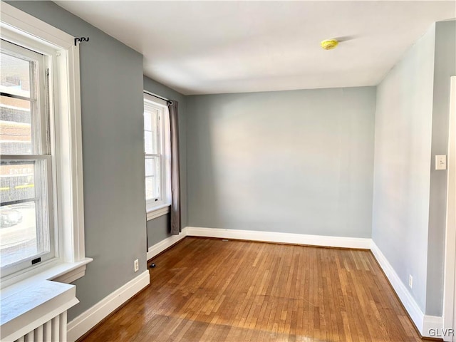 empty room with wood finished floors and baseboards