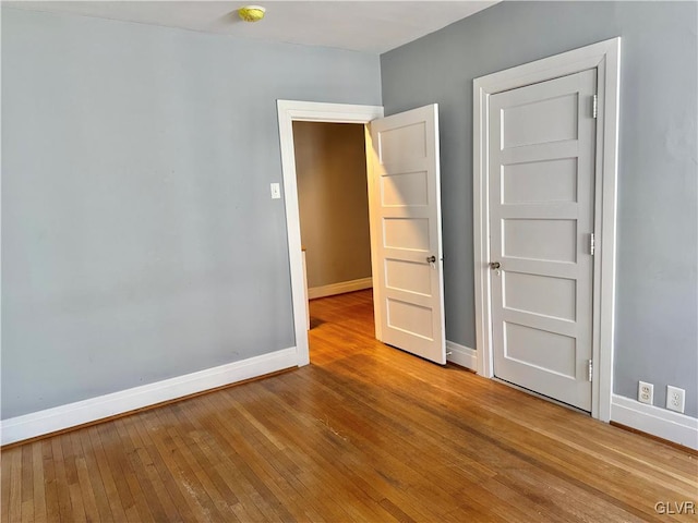 spare room with wood finished floors and baseboards