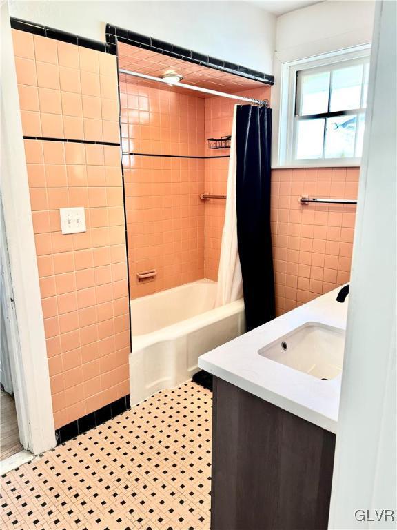 bathroom with shower / bath combo, vanity, tile walls, and tile patterned floors